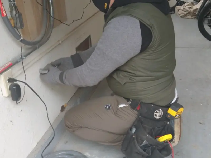 Electrician performing outlet wiring in a Easton garage
